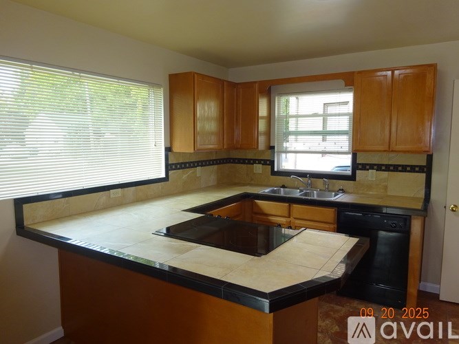 A kitchen with wooden cabinets and black countertops.