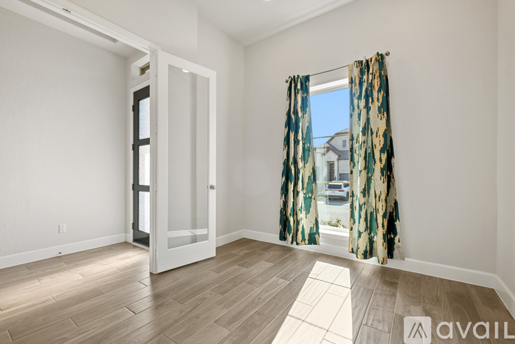 A room with a door and a window with curtains.