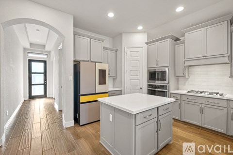 A modern kitchen with white cabinets and a central island.
