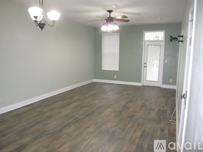 A room with wood flooring and a ceiling fan.