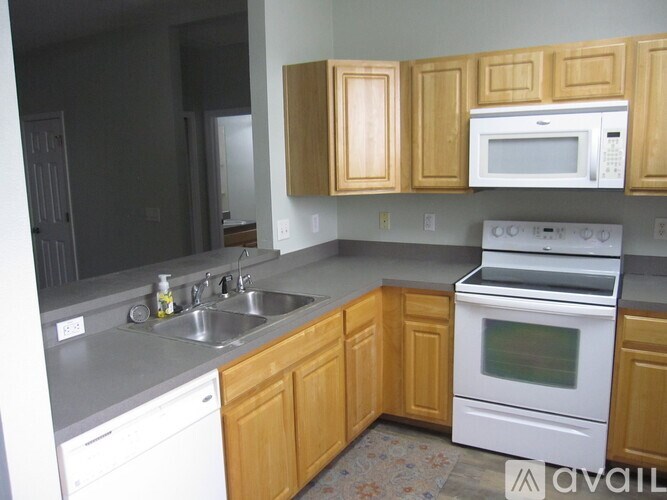 A kitchen with wooden cabinets and white appliances.