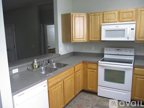 A kitchen with wooden cabinets and white appliances.