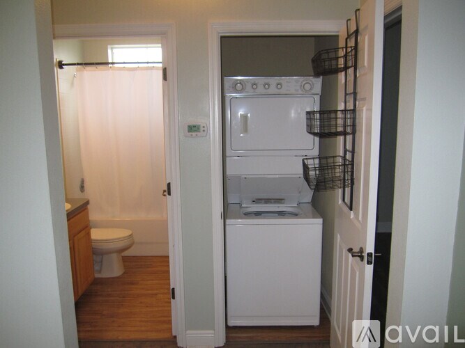 A small kitchen with a white fridge and a toilet.