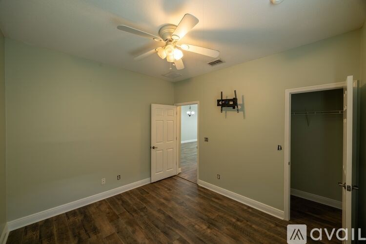 A room with a ceiling fan and a door.