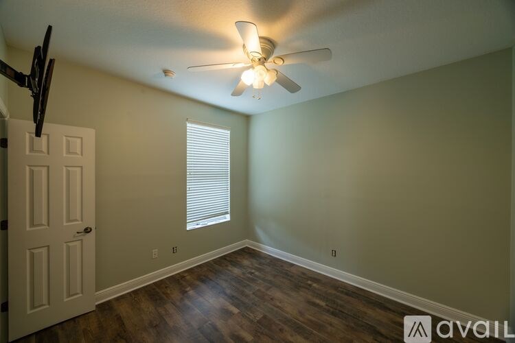 A room with a ceiling fan and a door.