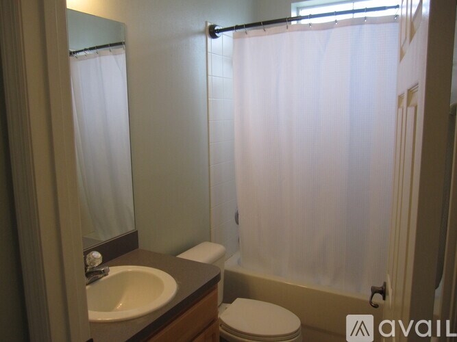 A bathroom with a sink, toilet and shower curtain.