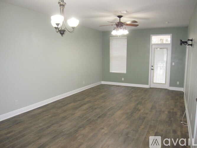A room with wood flooring and a ceiling fan.