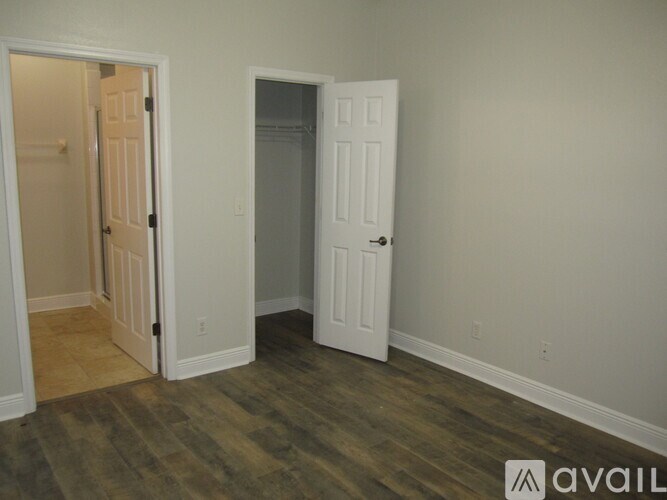 Two white doors in a room with wood flooring.