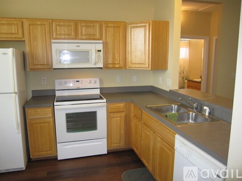 A kitchen with wooden cabinets and white appliances.