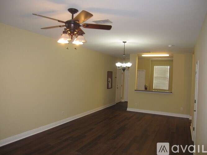 A room with a ceiling fan and chandelier.