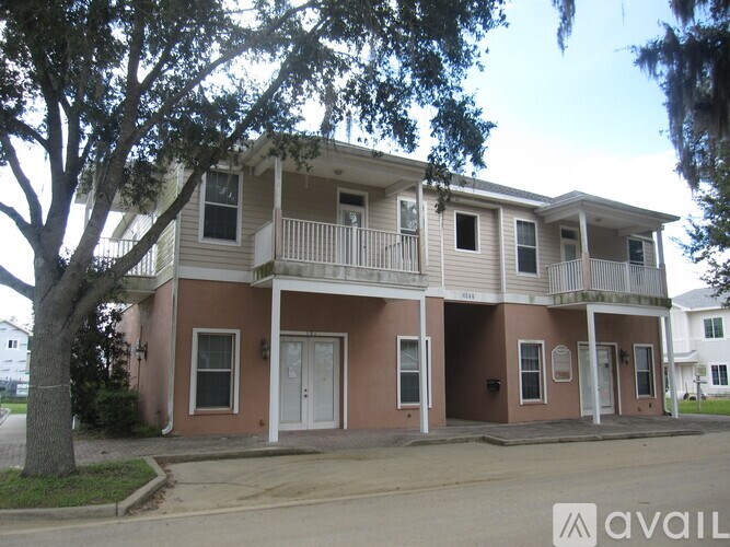 A two-story house with a balcony on the second floor.