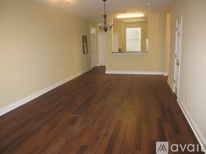 A room with wooden flooring and a chandelier.