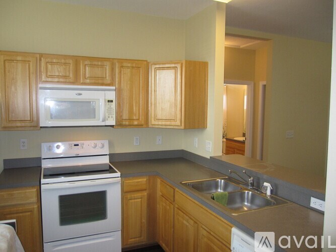A kitchen with wooden cabinets and a white oven.