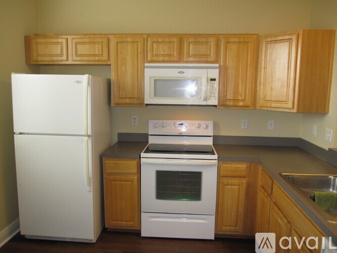 A kitchen with a white fridge, white microwave, and white oven.