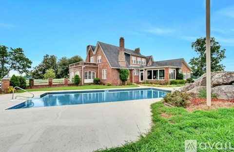 A large house with a pool in front.