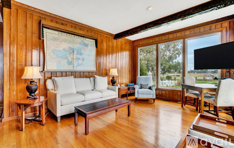 A living room with a white couch and a wooden floor.