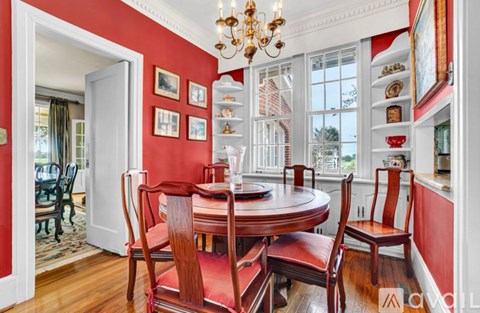 A dining room with a round table and chairs.