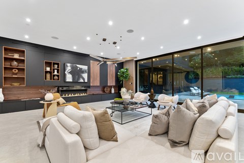 A modern living room with a glass table and white couches.