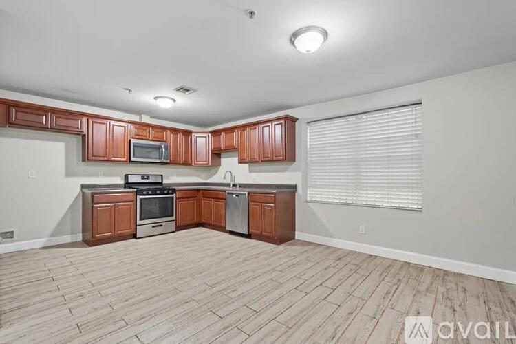 A kitchen with wooden cabinets and a stainless steel dishwasher.