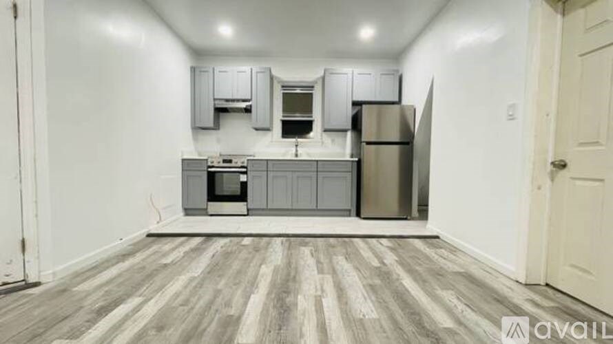 A kitchen with wooden flooring and white walls.