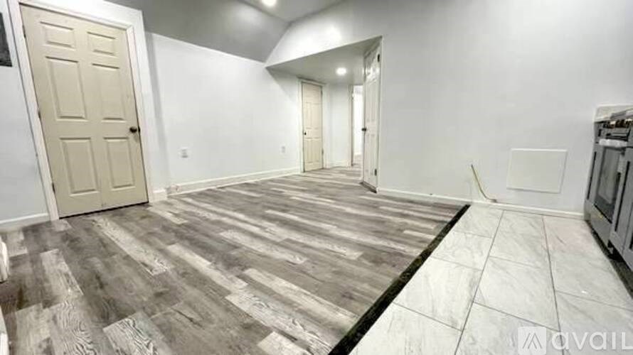A room with wooden flooring and white walls.