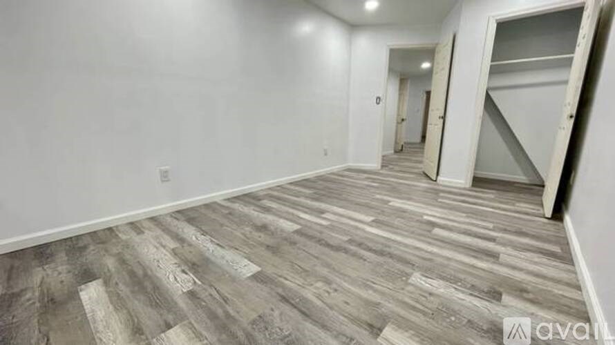 A room with wooden flooring and white walls is available for rent.