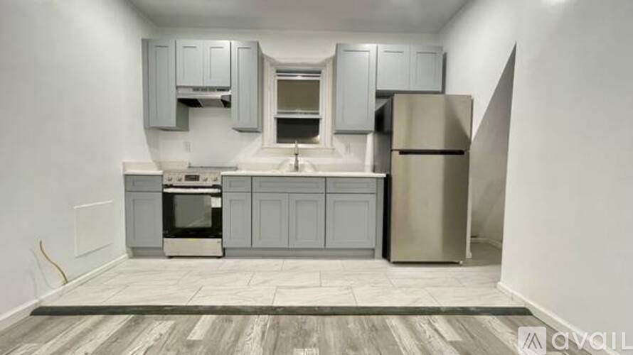 A kitchen with a refrigerator, oven, and sink.