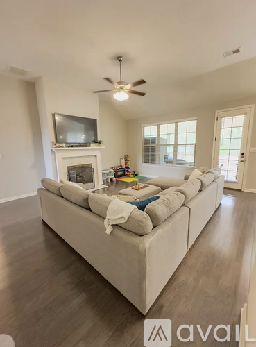 A living room with a white couch and a television on the wall.