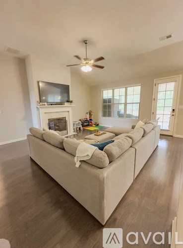 A living room with a white couch and a television on the wall.