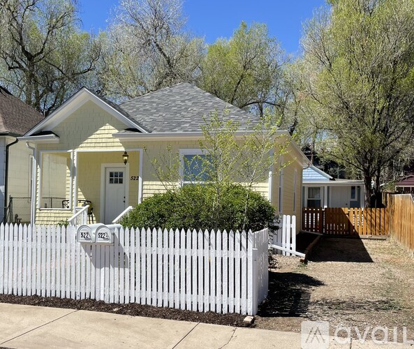 A small house with a grey front porch and a white door.