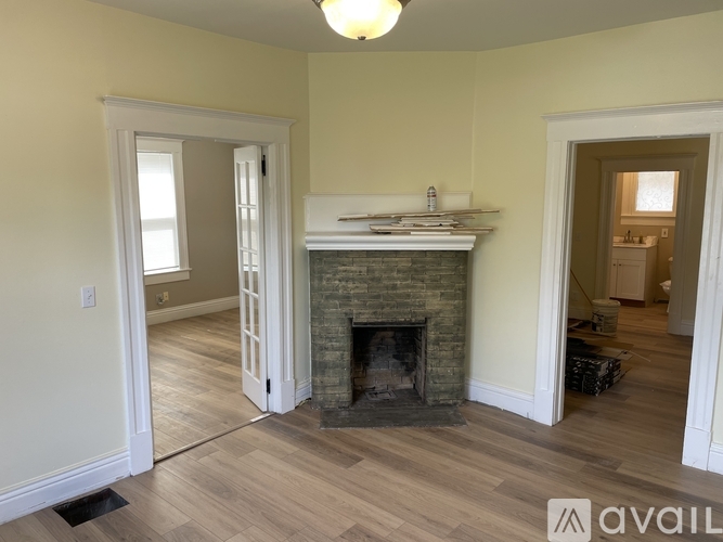 A living room with a fireplace and a light fixture.
