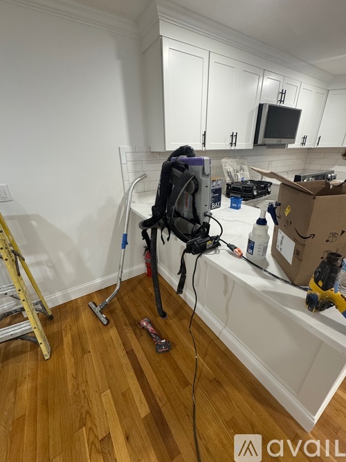 A room with a vacuum cleaner and a broom.