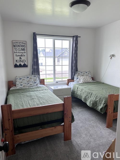 A bedroom with two beds and a poster on the wall.