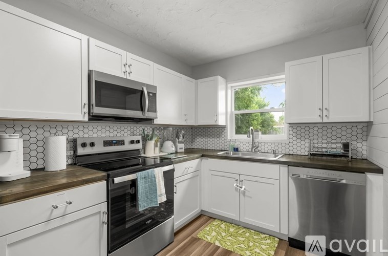 A kitchen with white cabinets and a black stove top.