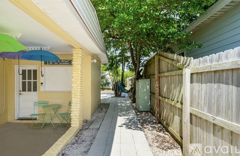 A patio with a table and chairs is surrounded by a wooden fence.