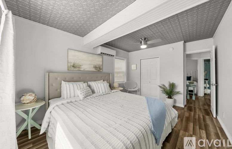 A bedroom with a large bed and a ceiling fan.