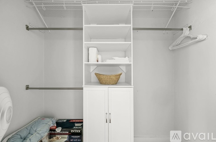 A white closet with a shelf and a basket on top.