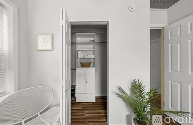 A white kitchen with a table and a plant.