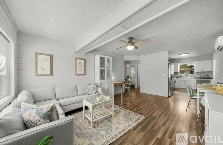 A living room with a grey couch and a white coffee table.