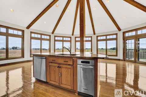 A kitchen with wooden cabinets and a large window.