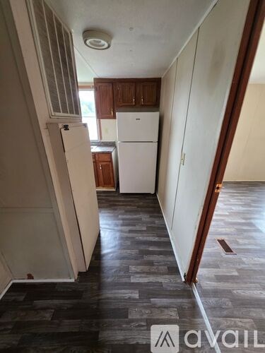 A kitchen with a white fridge and wooden cabinets.