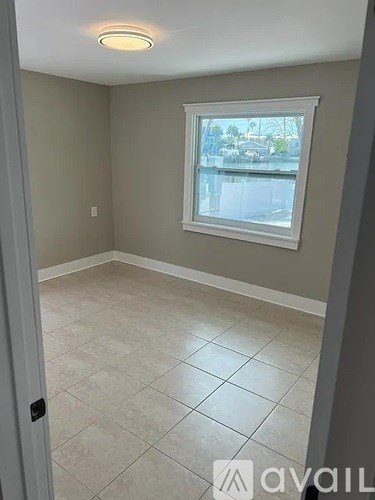 A room with a window and tiled floor.