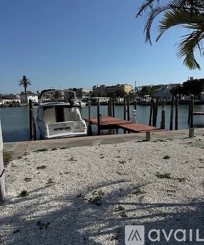 A boat is docked at a pier with a clear blue sky above.