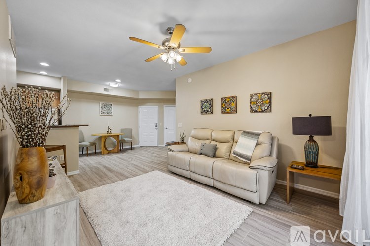 A patio with chairs and an umbrella overlooking a pool.