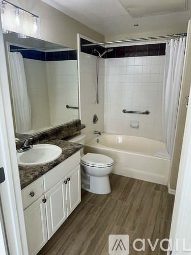 A bathroom with a toilet, sink, and bathtub.