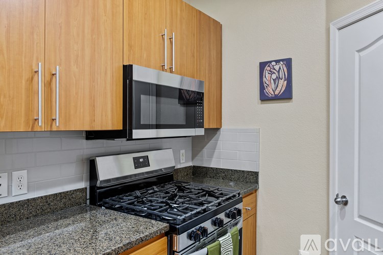 A spacious room with light wood flooring and two white doors.