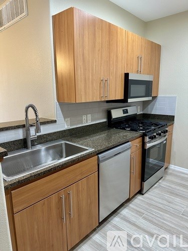 A kitchen with wooden cabinets and stainless steel appliances.