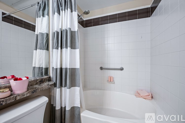 A room with a wooden table, a vase with flowers, a basket, and a rug.