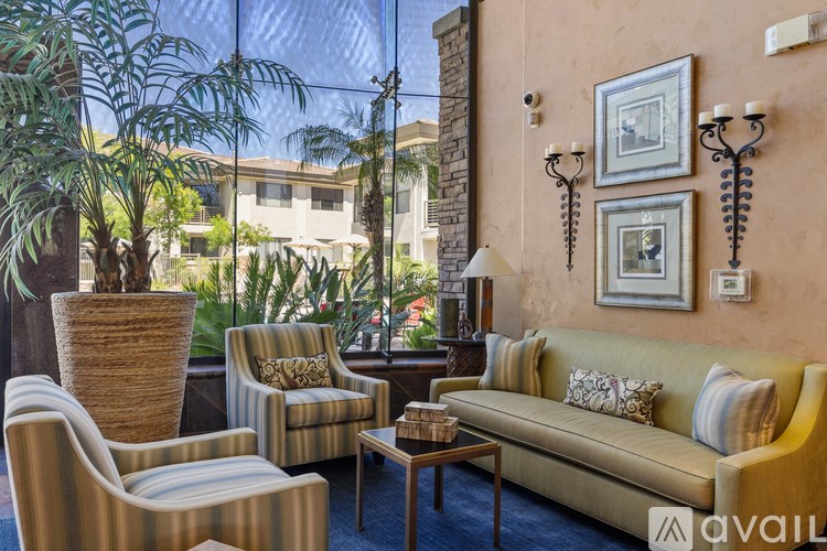 A gym with treadmills and a balcony with a railing.