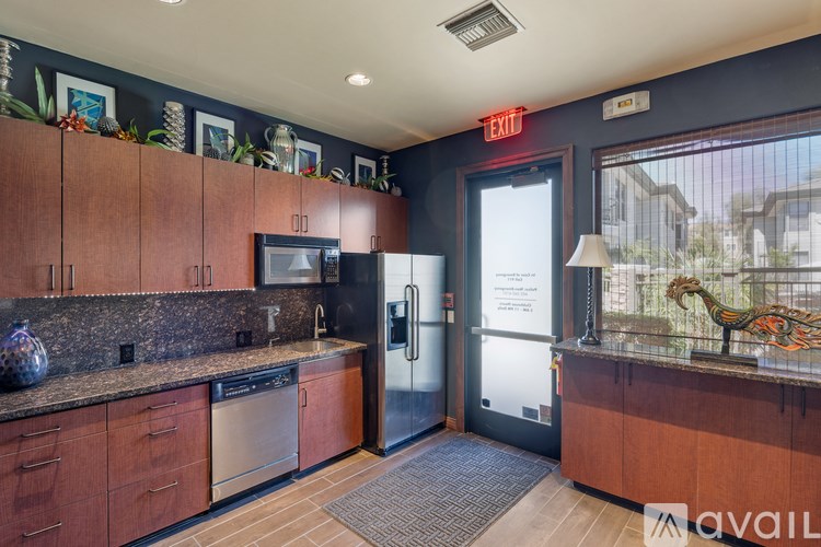 A kitchen with a refrigerator, sink, and cabinets.